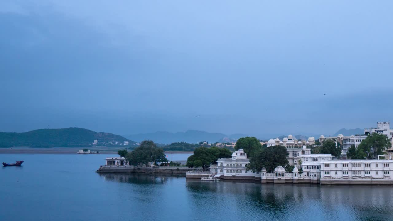 美丽的湖泊城市乌代普尔在清晨的4K延时。雨季时多云的天空。云和月亮在皮丘拉湖和城市建筑上移动。有旅游和度假背景。视频素材