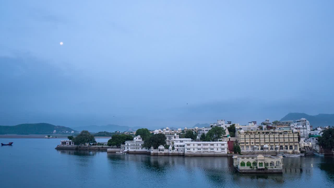 美丽的湖泊城市乌代普尔在清晨的4K延时。雨季时多云的天空。云和月亮在皮丘拉湖和城市建筑上移动。有旅游和度假背景。视频下载