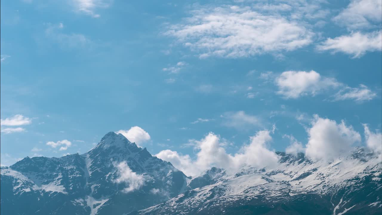 柔和的白云在印度喜马偕尔邦拉胡尔的雪山上移动。山上的季风云。自然景观。史诗般的喜马拉雅山时间流逝。视频下载