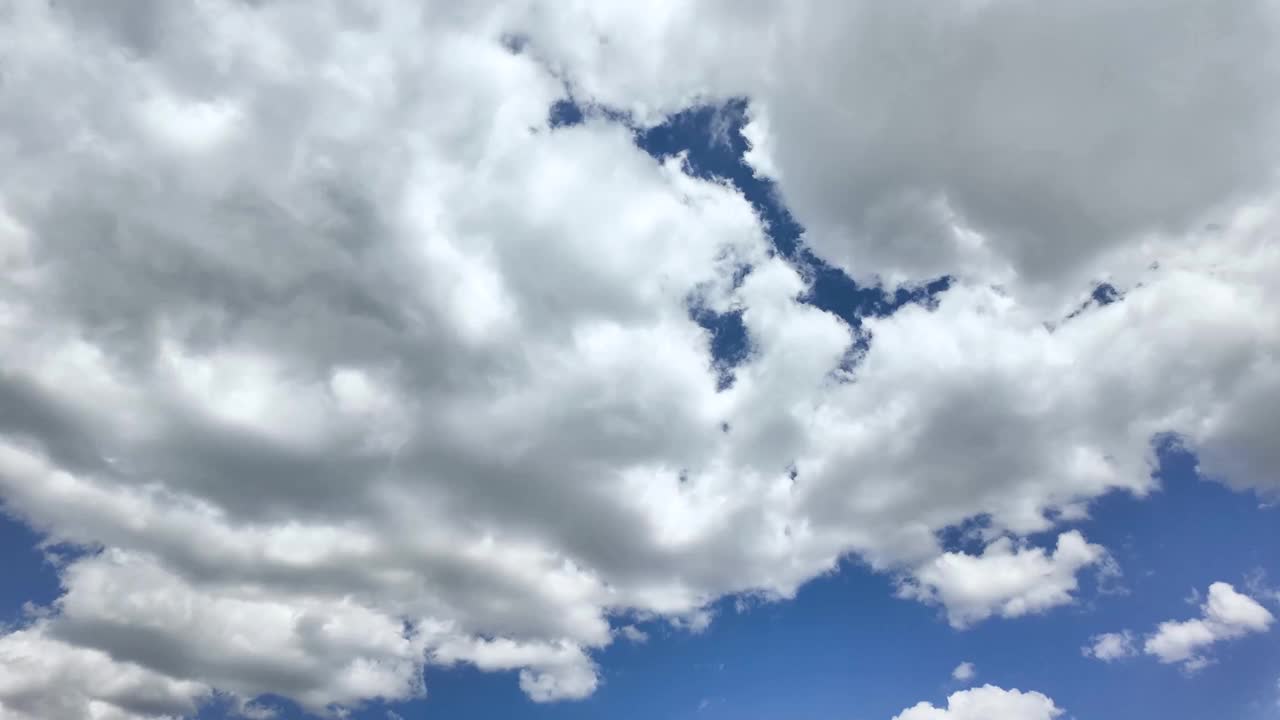 夏日蓝天上，雷暴前形成的白色蓬松积雨云。移动和变化的云景天气视频素材