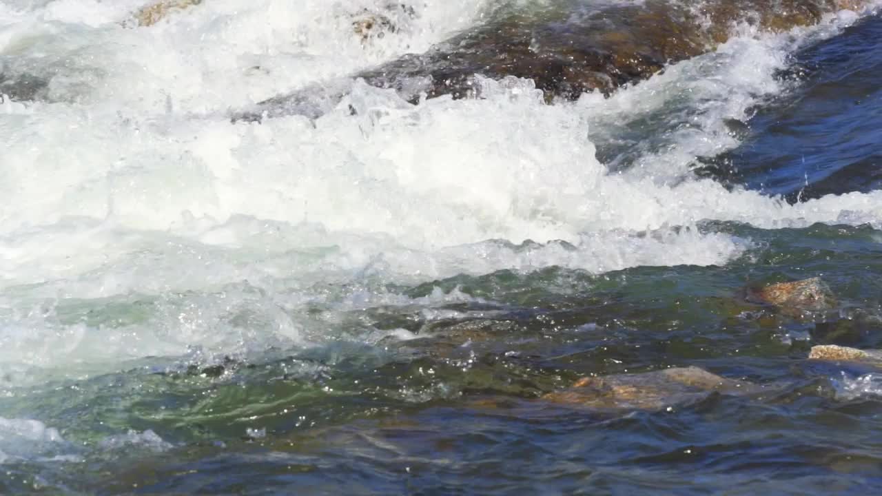 泉水湍急的河水流过小岩石，慢动作视频视频下载