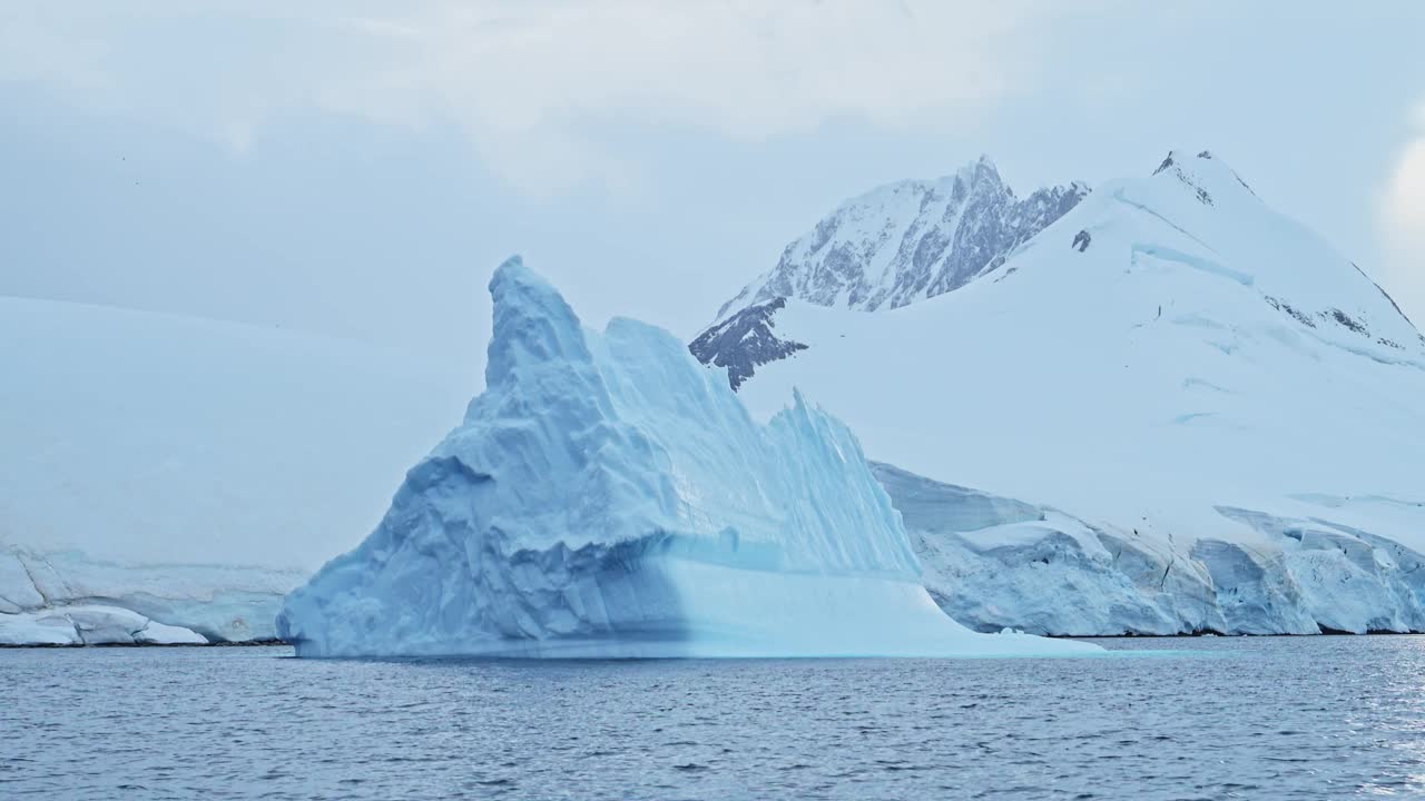 全球变暖的海洋和海洋在南极洲的山脉和冰山景观风景，气候变化与变暖的水在美丽戏剧性的南极半岛冬季场景视频素材