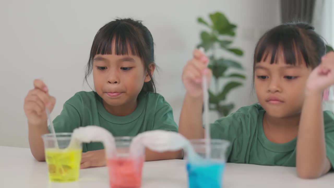 两个小女孩正在玩桌上的化学试剂视频下载