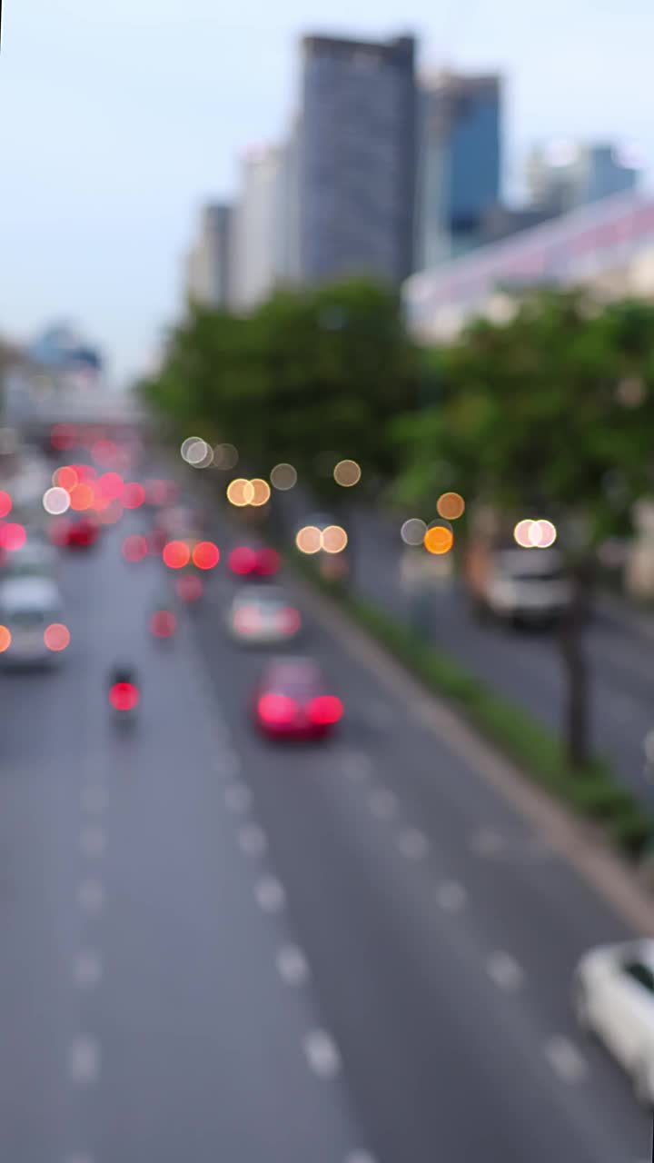 泰国曼谷的道路交通。汽车散景和模糊的交通灯。垂直视频。视频下载