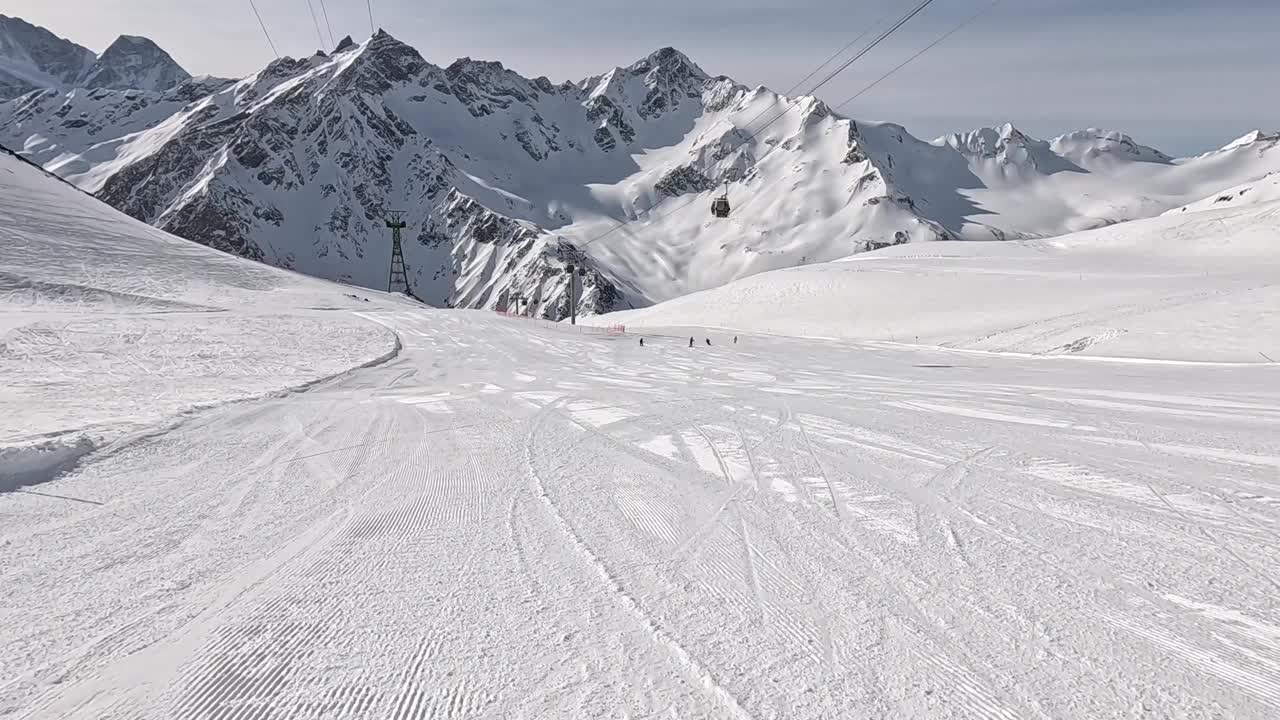 在晴朗的冬日，贡多拉缆车在白雪皑皑的高山上缓缓升起视频下载