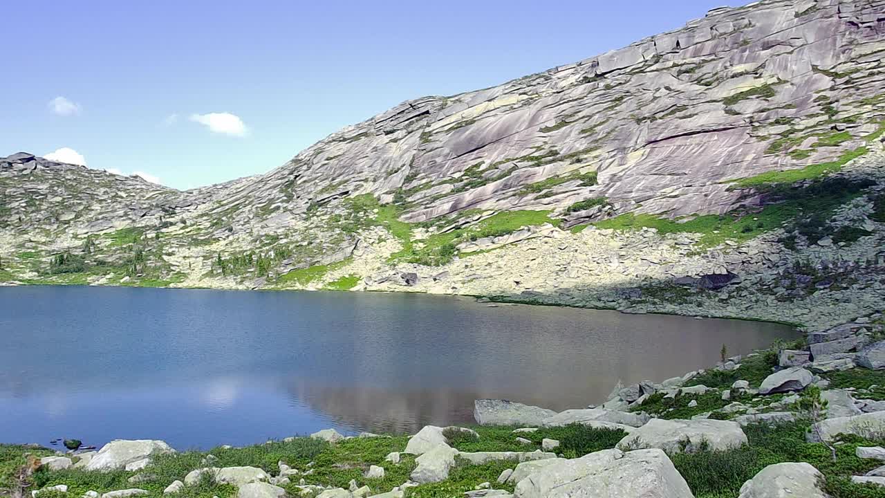 在一个阳光明媚的夏日早晨，低空飞越一个被高山环绕的风景如画的大湖。视频下载