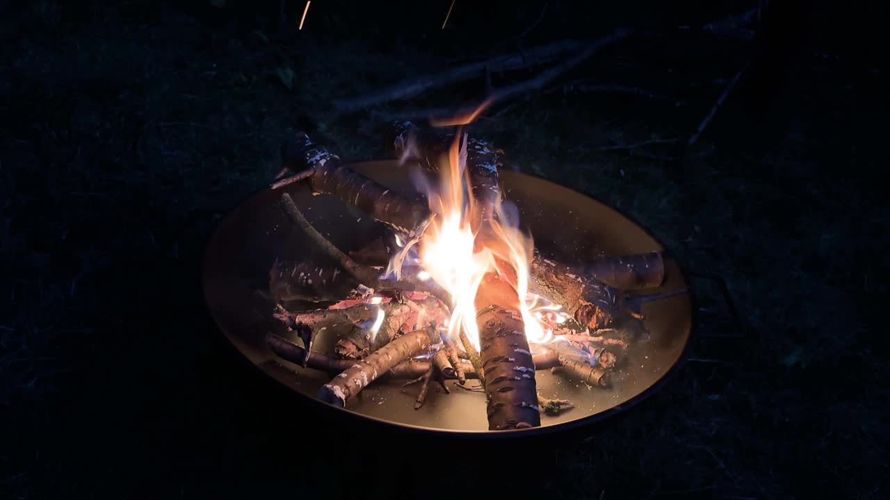 夜晚的篝火在金属壁炉里。在外面露营视频素材