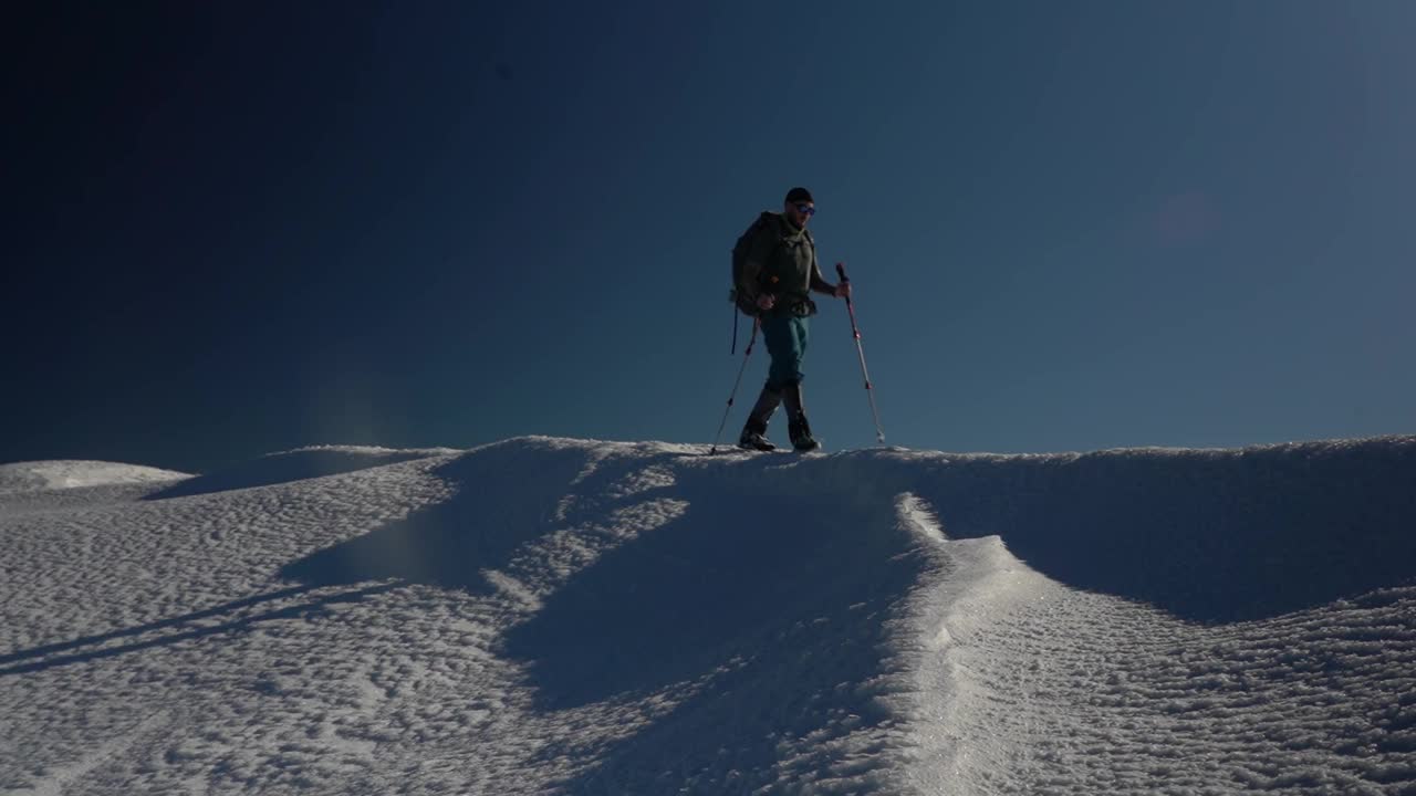 在阳光明媚的日子里，在山顶上进行雪上徒步旅行。戈尔甘尼山脉在冬季。喀尔巴阡山脉，乌克兰视频下载