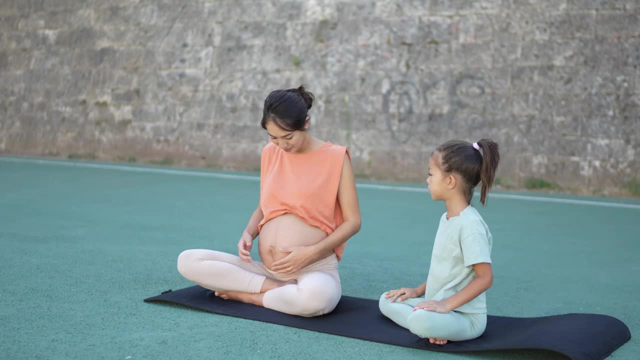 美丽微笑的孕妇和她的女儿在户外视频下载