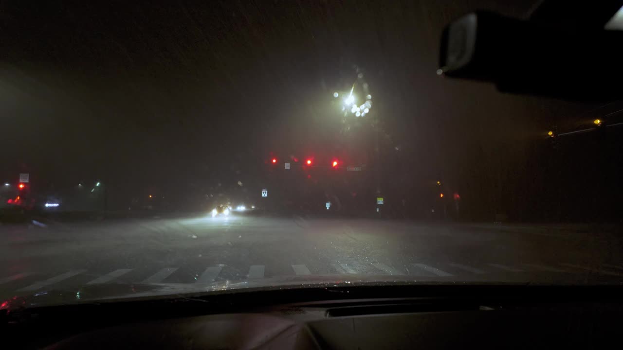 在夜间暴风雨时间，车窗外的闪电击中了驾驶车内的正面镜头。视频素材