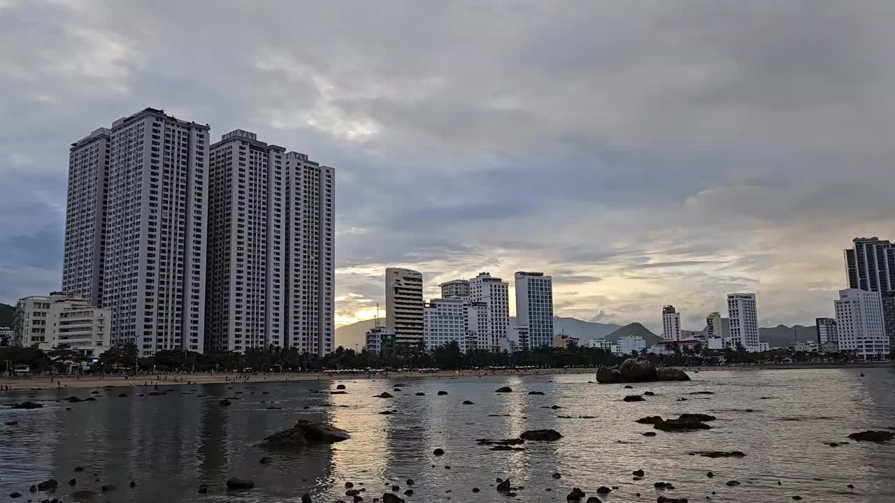 夕阳下的越南芽庄市的海滩、海滨和高层建筑。视频素材