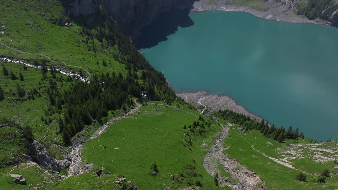 在瑞士伯尔尼高地的Oeschinensee湖上，一名男子在山顶上的景色。空中回射视频素材