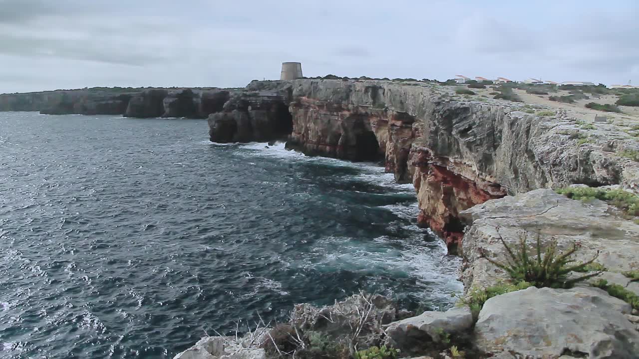 Punta Prima悬崖和日出时的防御塔。西班牙巴利阿里群岛的福门特拉岛。视频下载