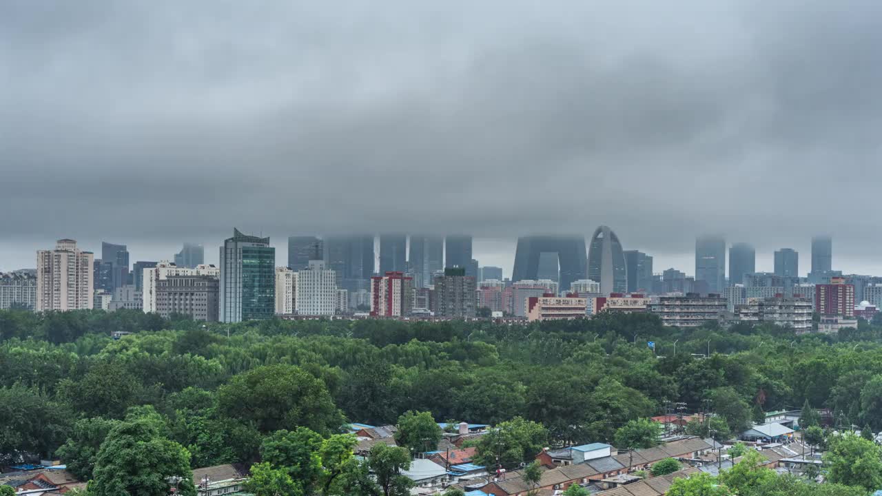 中国北京城市高层建筑穿过云海，下雨天建筑云海视频下载