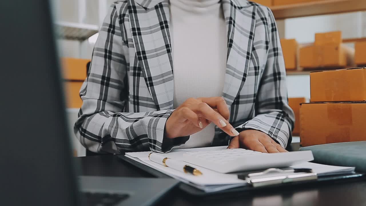 年轻的亚洲女性在家网上购物，联系顾客送货。视频下载