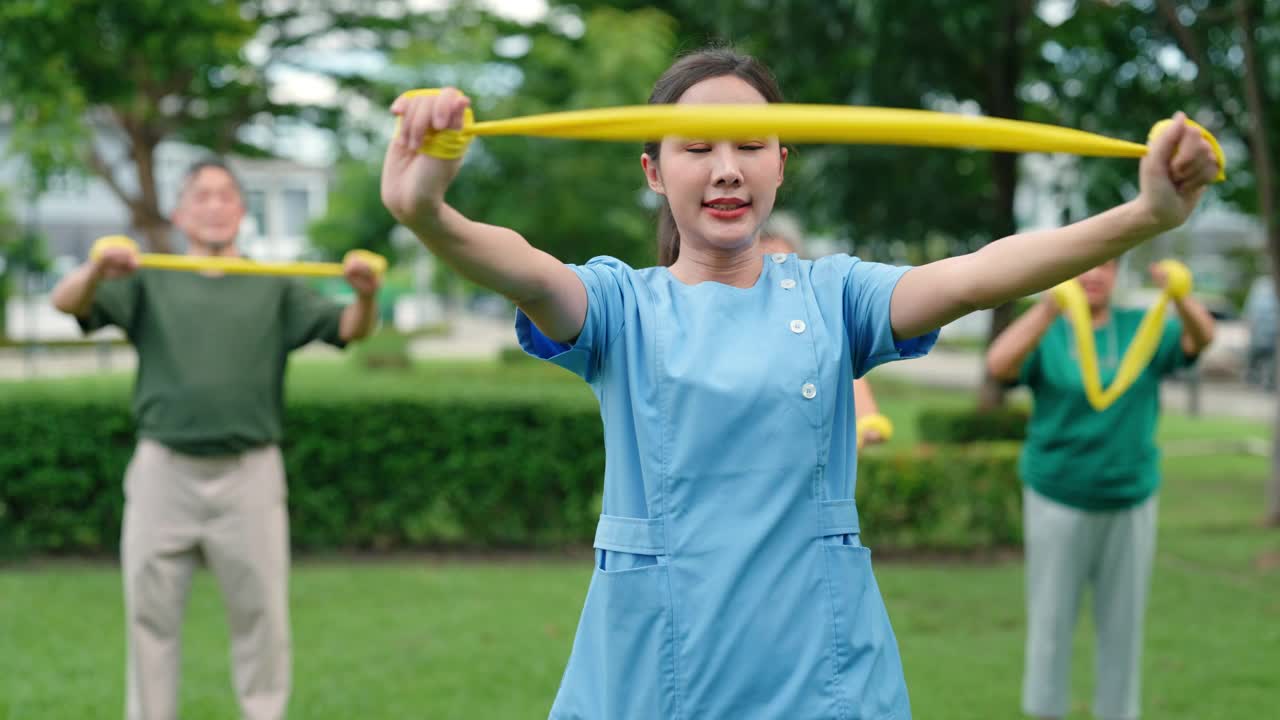 一位护士正在草坪上帮助一位老人锻炼身体。视频素材