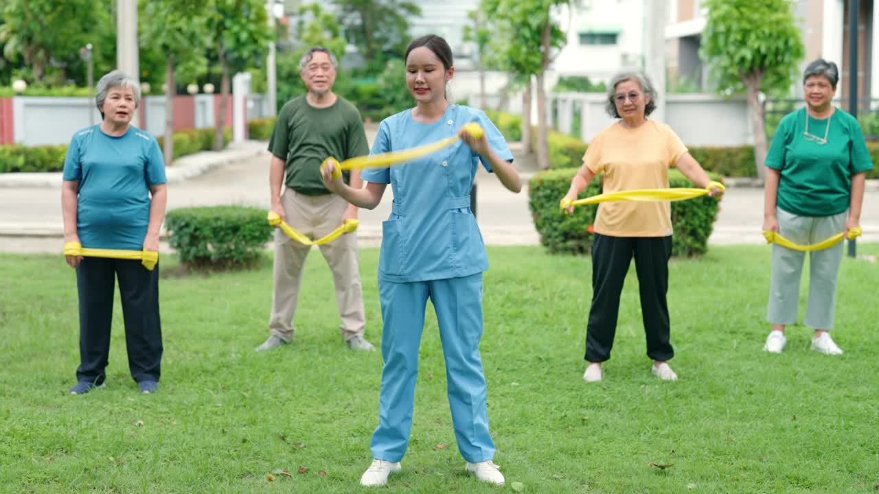 一位护士正在草坪上帮助一位老人锻炼身体。视频素材