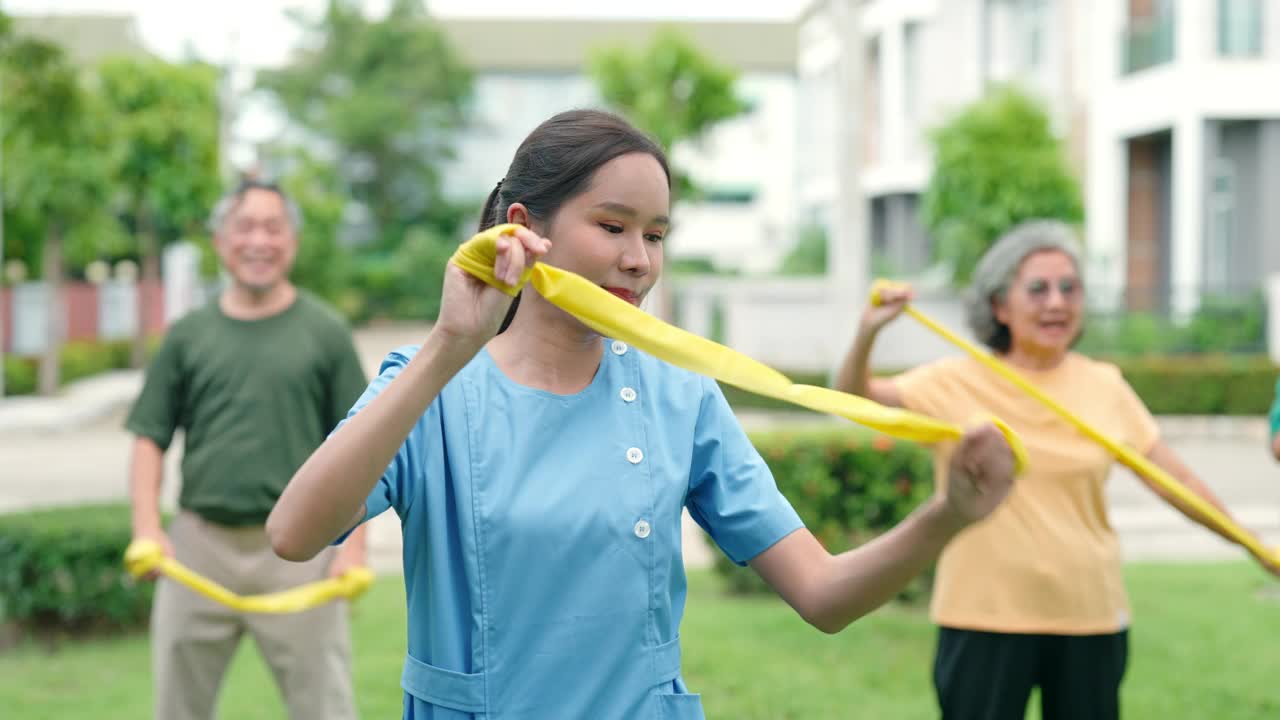 一位护士正在草坪上帮助一位老人锻炼身体。视频素材