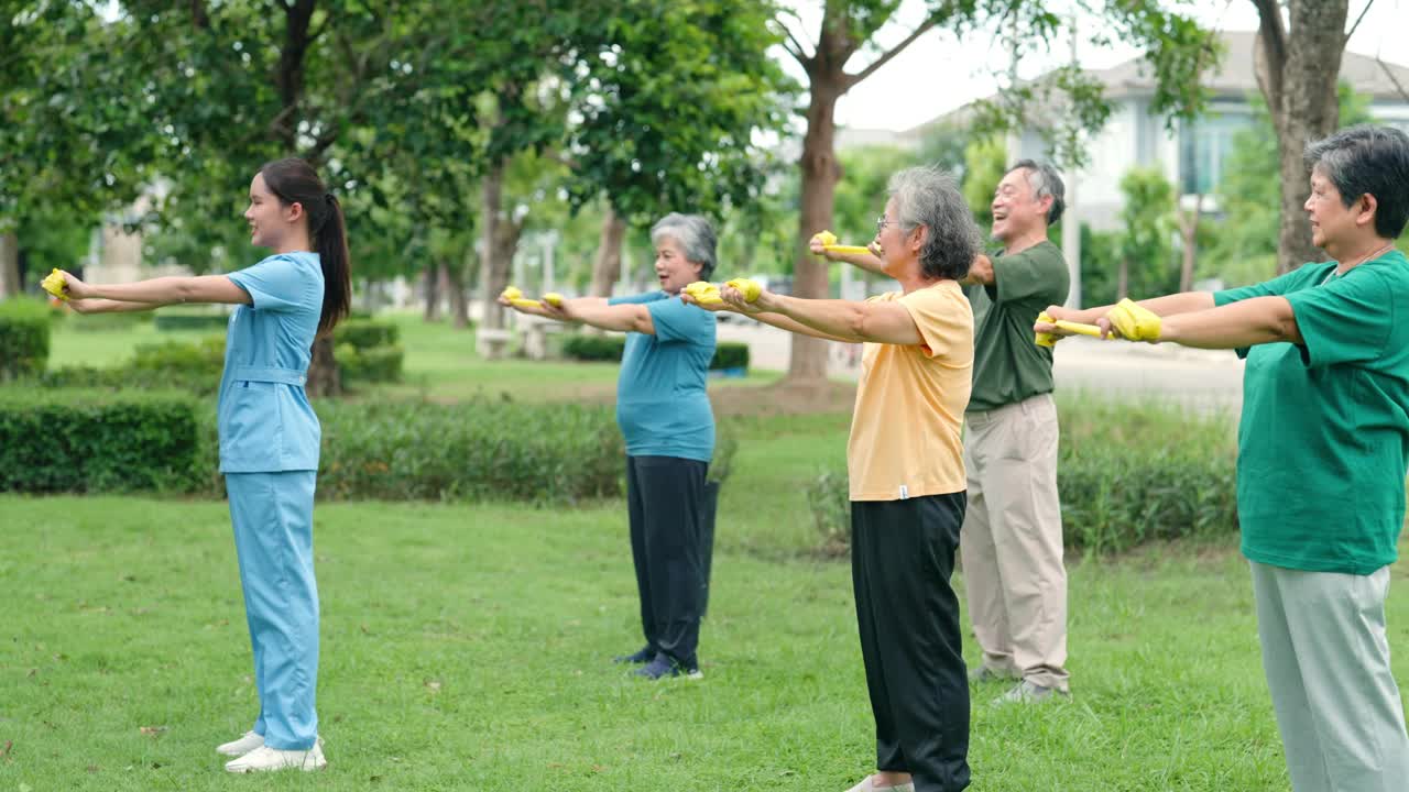 一位护士正在草坪上帮助一位老人锻炼身体。视频素材