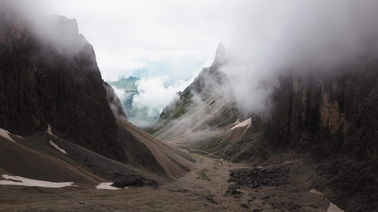 陡峭的岩石峡谷穿过一个山谷，有许多云和绿色的草地在背景，白云岩，意大利，欧洲，无人机视频素材