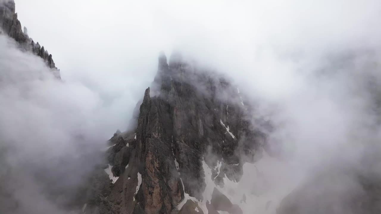 陡峭的岩面与云和雪在山上，白云岩，意大利，欧洲，无人机视频素材