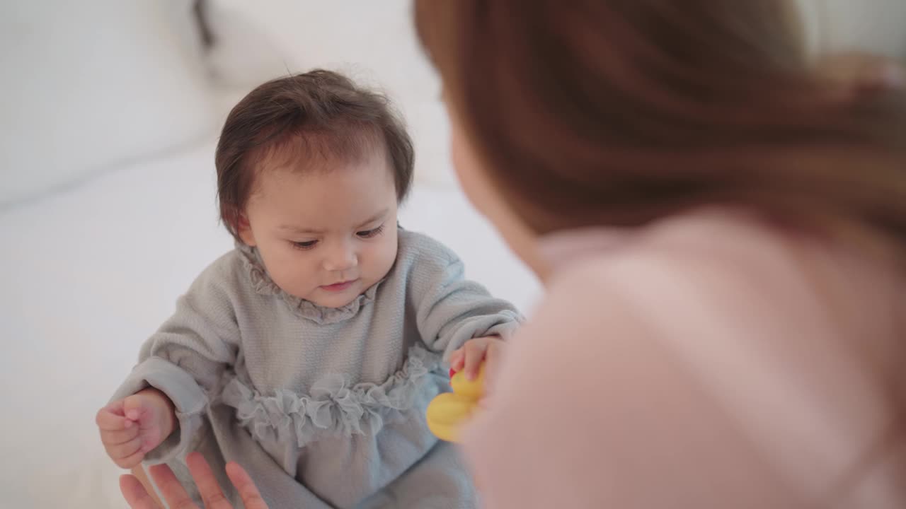 一位亚洲母亲在床上和她的女儿玩耍视频素材