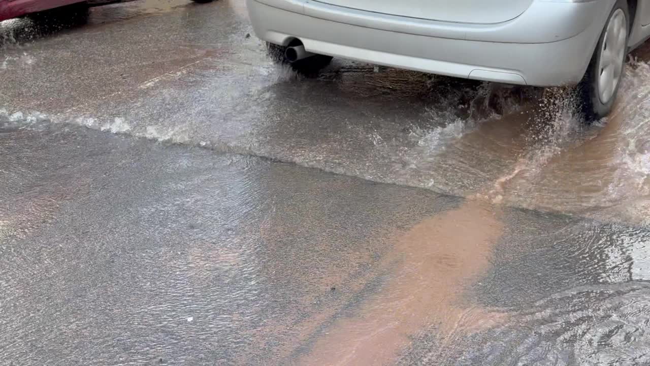 在城市的下雨天，水从街上的沙井里流出来视频素材