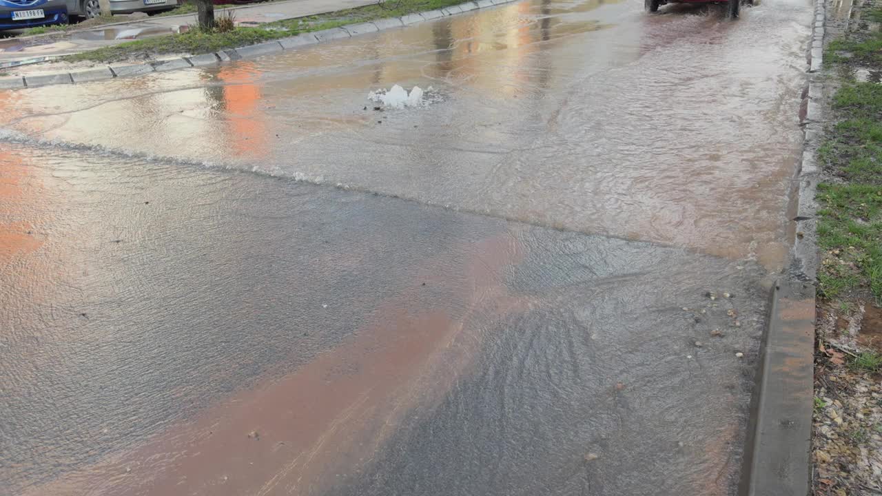 在城市的下雨天，水从街上的沙井里流出来视频素材