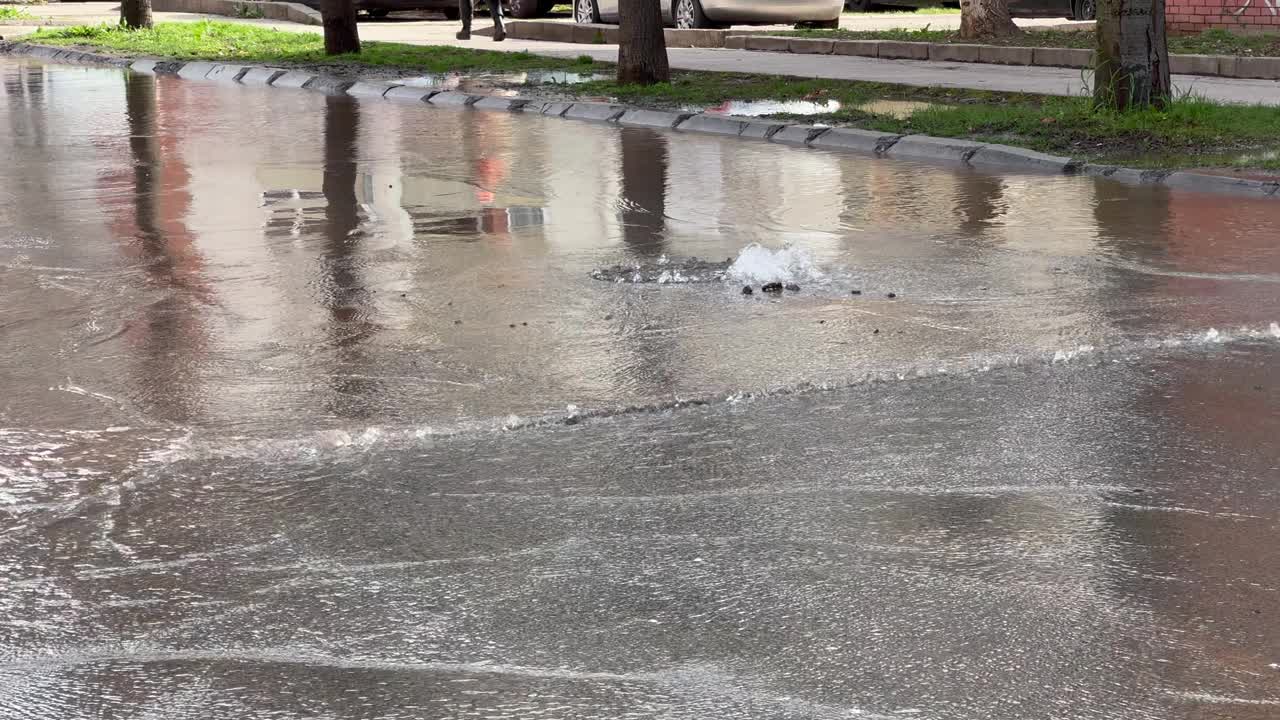 在城市的下雨天，水从街上的沙井里流出来视频素材