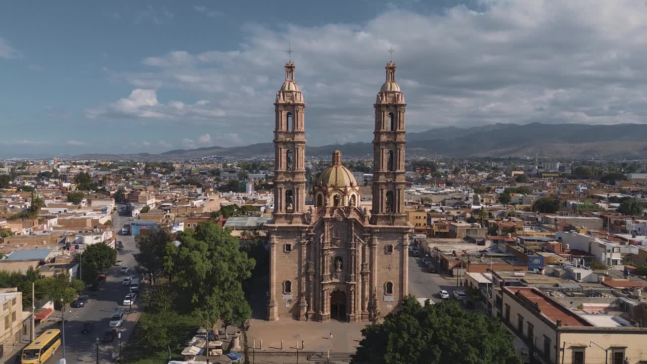 鸟瞰教堂Parroquia Basilica Santuario de Nuestra Señora de Guadalupe日落时的城市背景，美丽的宗教天主教建筑视频下载