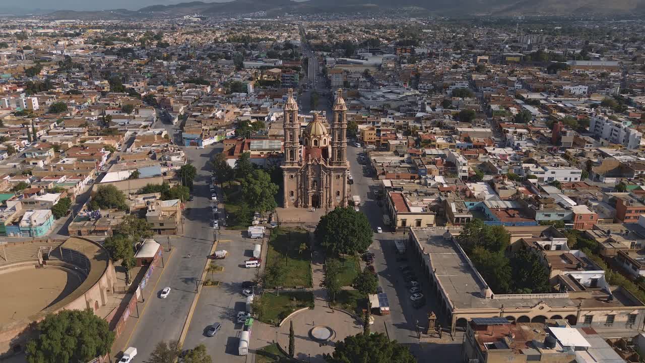 鸟瞰教堂Parroquia Basilica Santuario de Nuestra Señora de Guadalupe日落时的城市背景，美丽的宗教天主教建筑视频下载