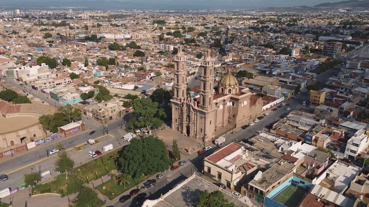 鸟瞰教堂Parroquia Basilica Santuario de Nuestra Señora de Guadalupe日落时的城市背景，美丽的宗教天主教建筑视频下载