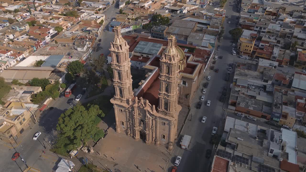 鸟瞰教堂Parroquia Basilica Santuario de Nuestra Señora de Guadalupe日落时的城市背景，美丽的宗教天主教建筑视频素材