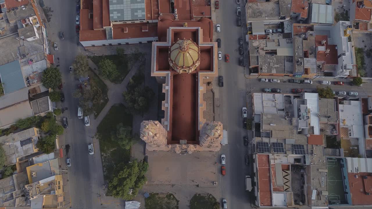 鸟瞰教堂Parroquia Basilica Santuario de Nuestra Señora de Guadalupe日落时的城市背景，美丽的宗教天主教建筑视频下载