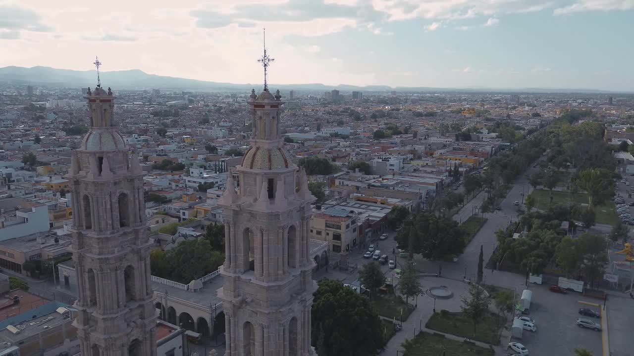 鸟瞰教堂Parroquia Basilica Santuario de Nuestra Señora de Guadalupe日落时的城市背景，美丽的宗教天主教建筑视频素材