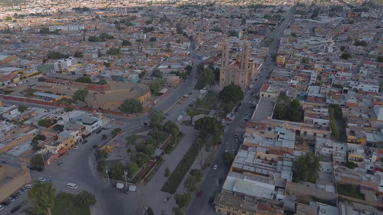 鸟瞰教堂Parroquia Basilica Santuario de Nuestra Señora de Guadalupe日落时的城市背景，美丽的宗教天主教建筑视频下载