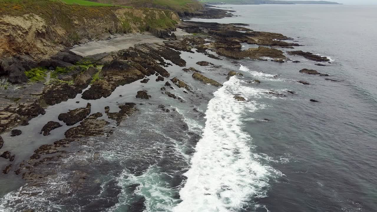 岩石海岸线的景色，前景是水，背景是悬崖。视频素材