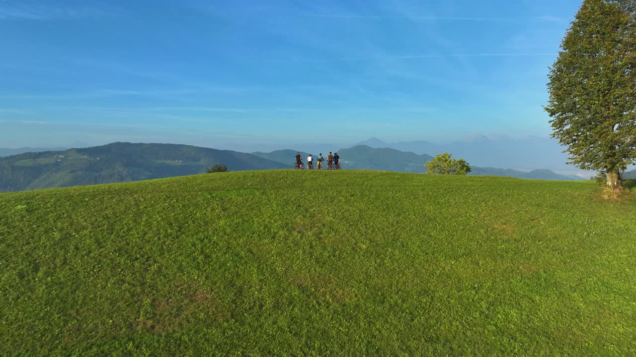 航拍:朋友们在青翠的山上骑车，在风景优美的地方休息。视频素材