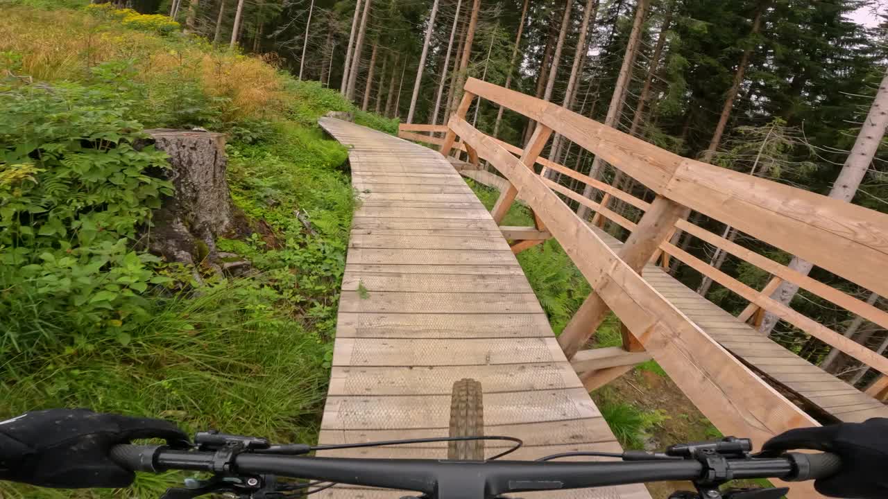 POV:骑山地车沿着一条快速下坡的木板走。视频素材