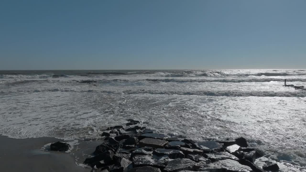 航拍的波涛汹涌的海浪在一个阳光明媚的日子。视频素材