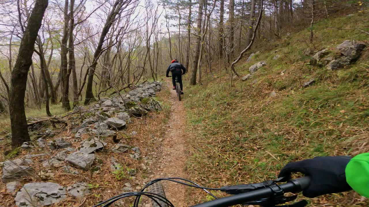 POV:在风景如画的林地里跟着朋友骑山地车。视频素材