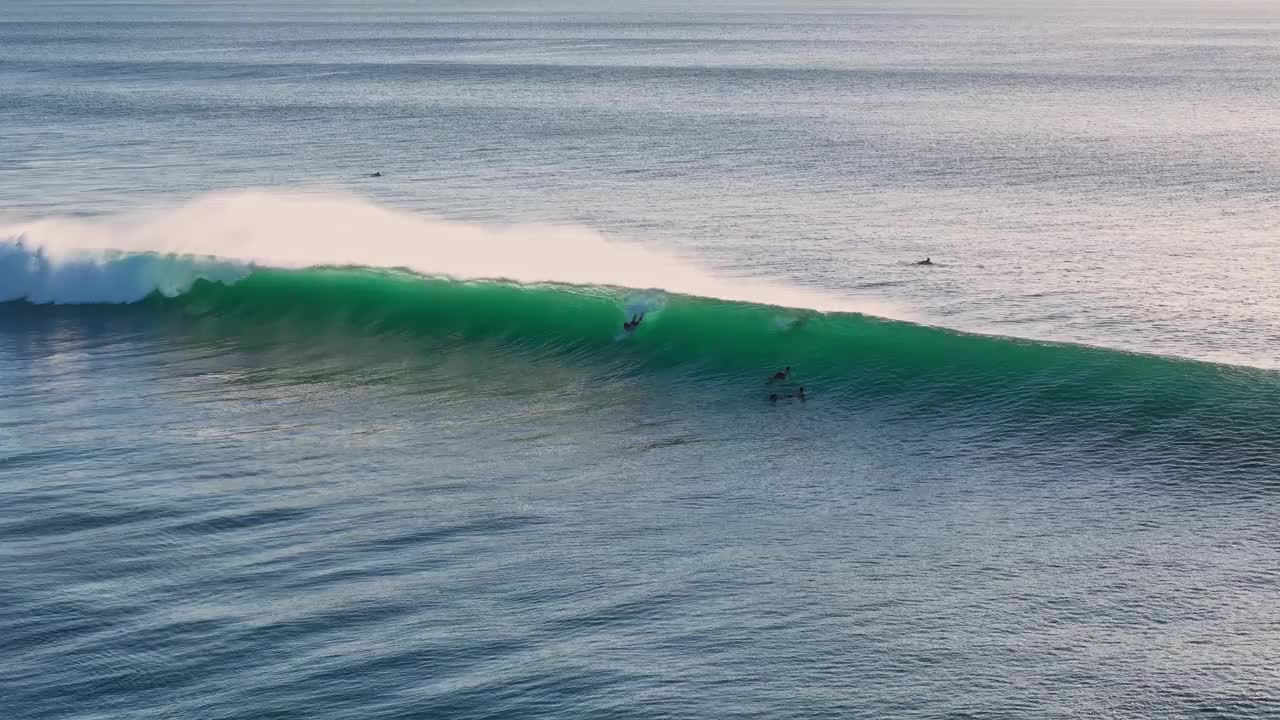 无人机在理想的海浪上冲浪。与冲浪者在巴厘岛的海洋完美的海浪视频下载