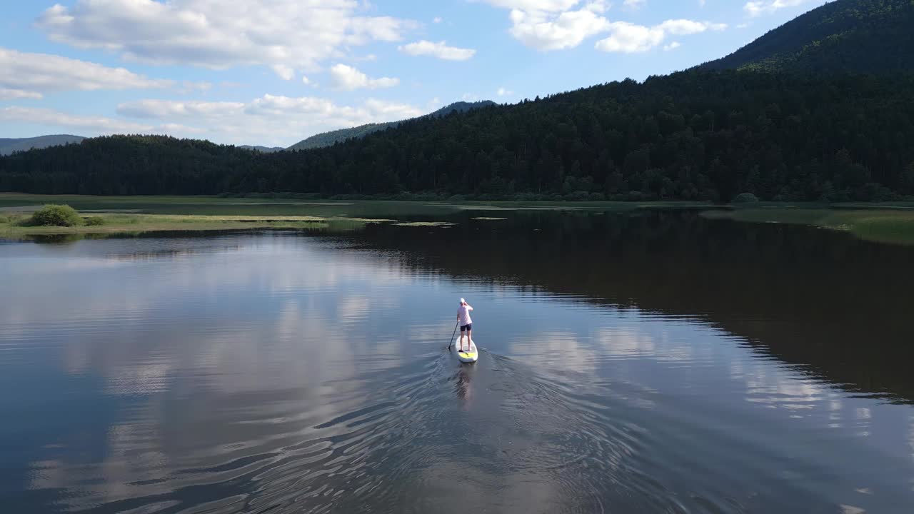 一个人站在山上的湖上，放松和享受自然视频素材