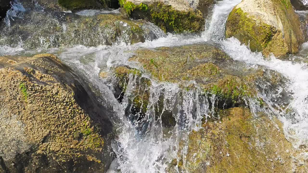 在瑞士格拉鲁斯的威森，河水从岩石和石头上倾泻而下，彰显了大自然的美丽。视频素材