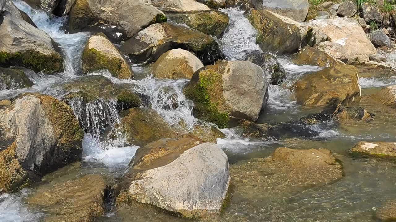 在瑞士格拉鲁斯的威森，河水从岩石和石头上倾泻而下，彰显了大自然的美丽。视频素材