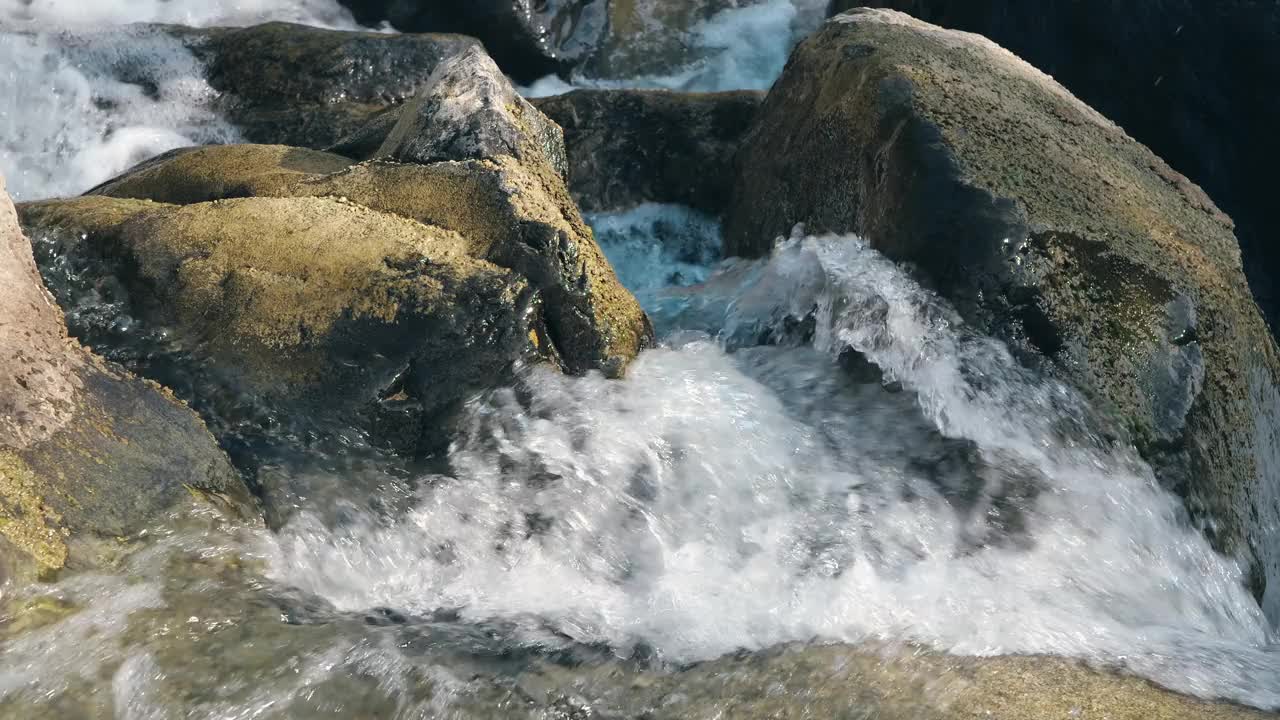 在瑞士格拉鲁斯的威森，河水从岩石和石头上倾泻而下，彰显了大自然的美丽。视频素材