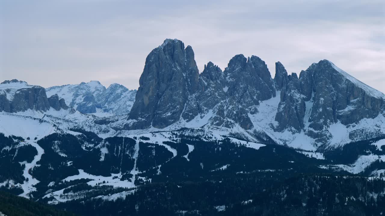 在晴朗的天空下，白雪覆盖的Sasso Lungo山脉的滑雪坡令人叹为观止的全景。视频素材