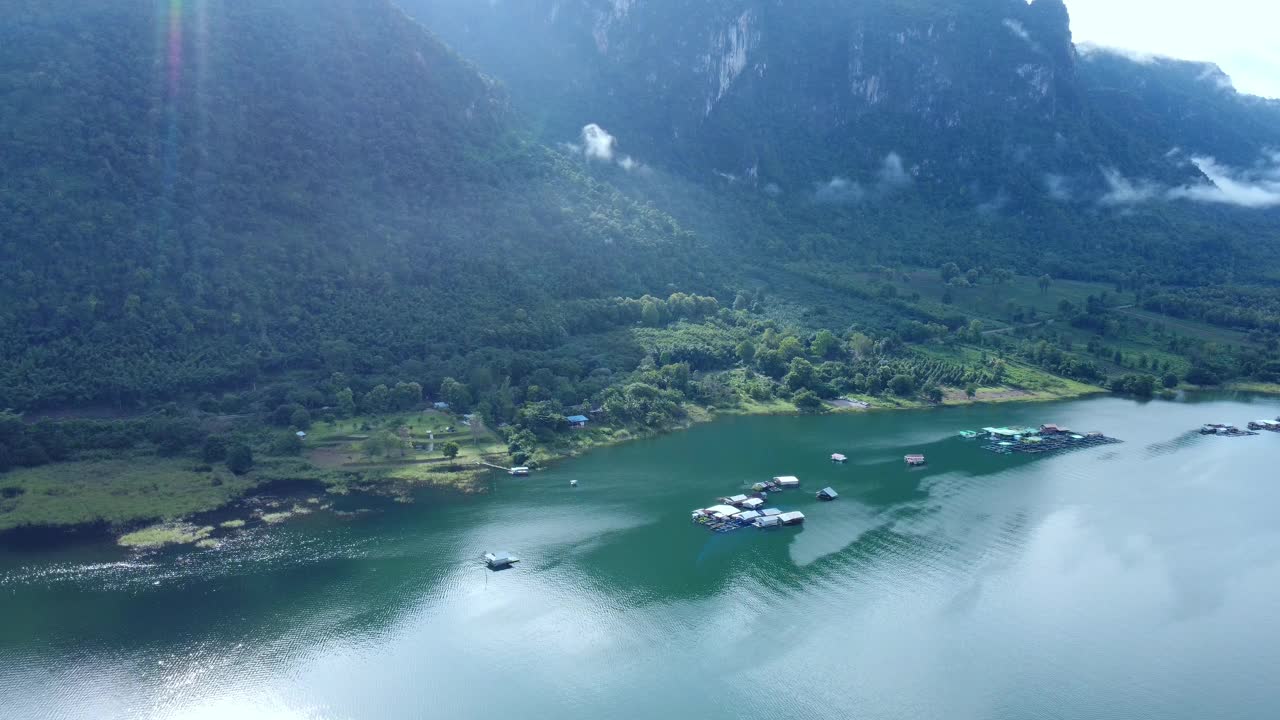 泰国北碧府哇集拉隆功大坝上漂浮小屋的美丽景色，背景是山脉和晨雾。漂浮的房子视频素材