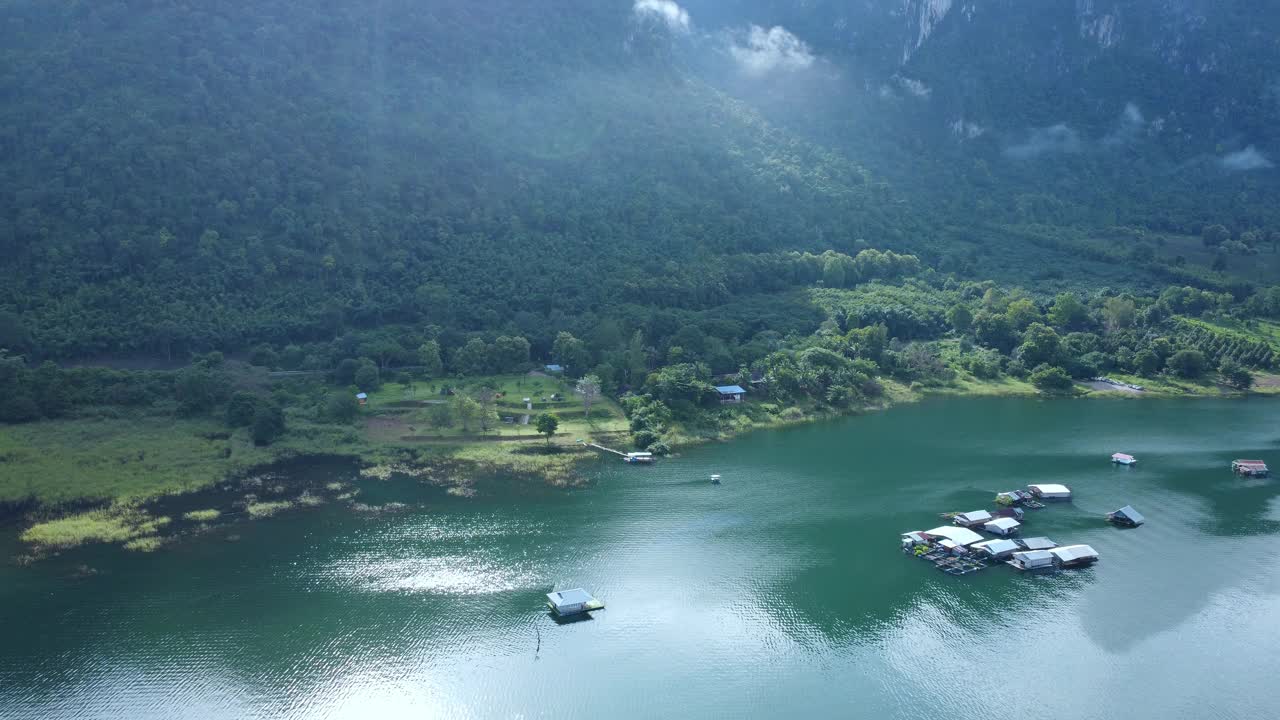 泰国北碧府哇集拉隆功大坝上漂浮小屋的美丽景色，背景是山脉和晨雾。漂浮的房子视频素材