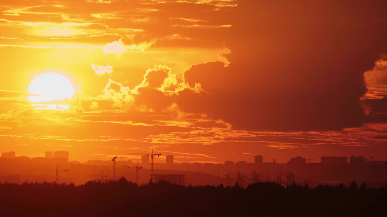 夕阳在城市景观上，地平线上有起重机和建筑物，时间流逝。城市天际线摄影海报，壁纸，横幅，标题视频下载